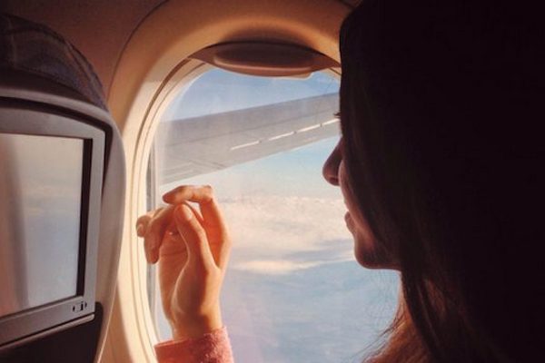 person-looking-out-plane-window